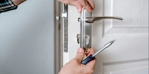 Professional locksmith in Tulsa repairing a door lock